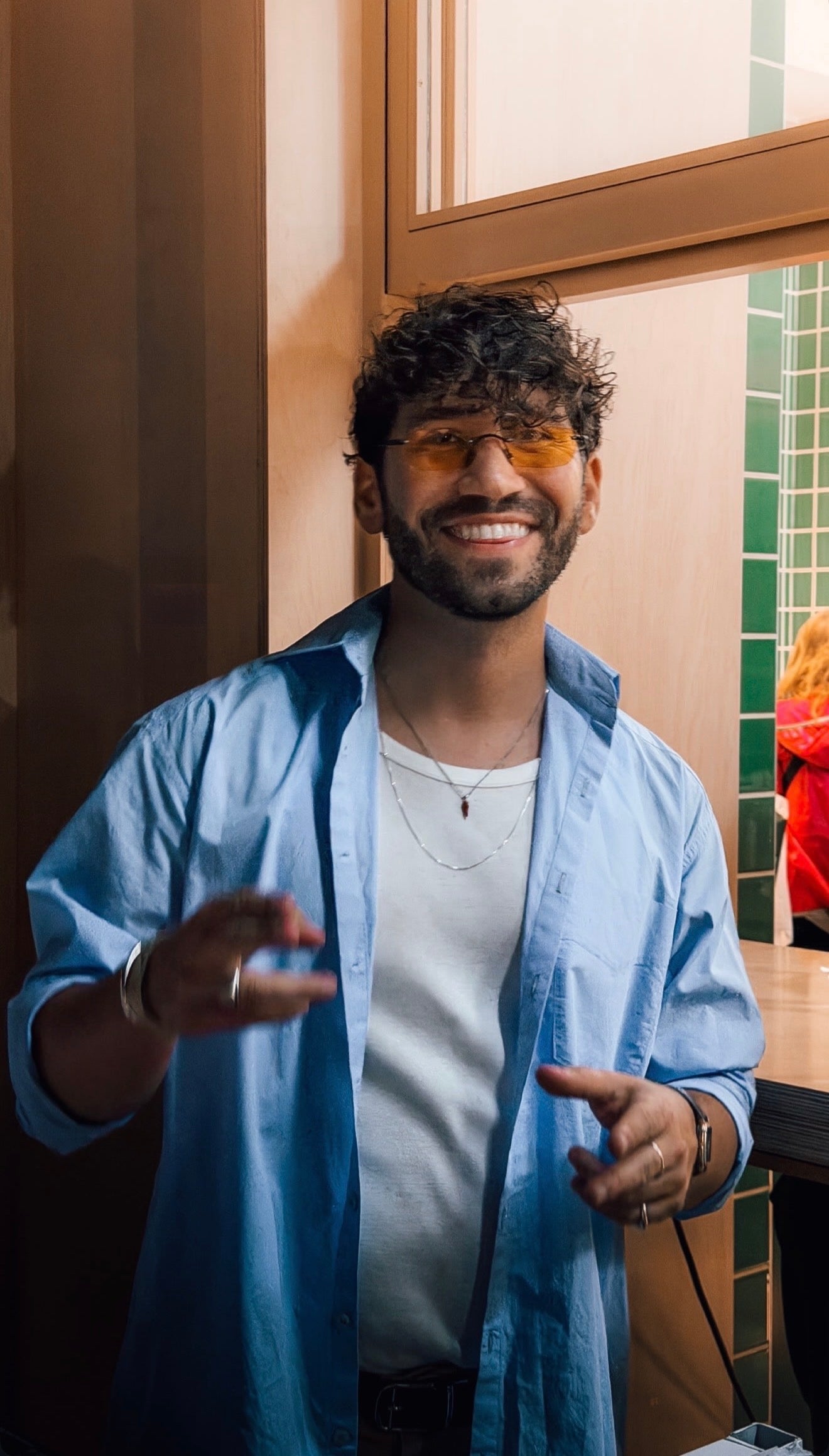 Man wearing a blue shirt and white t-shirt indoors