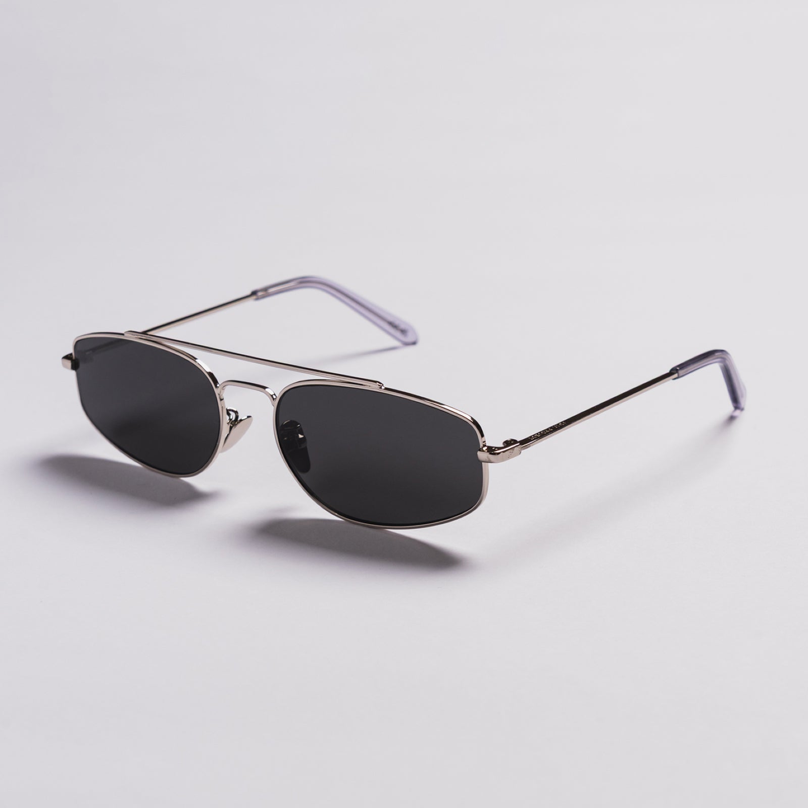 Silver frame sunglasses with dark lenses on a white background. Aviator style. Brand VOYA Project.