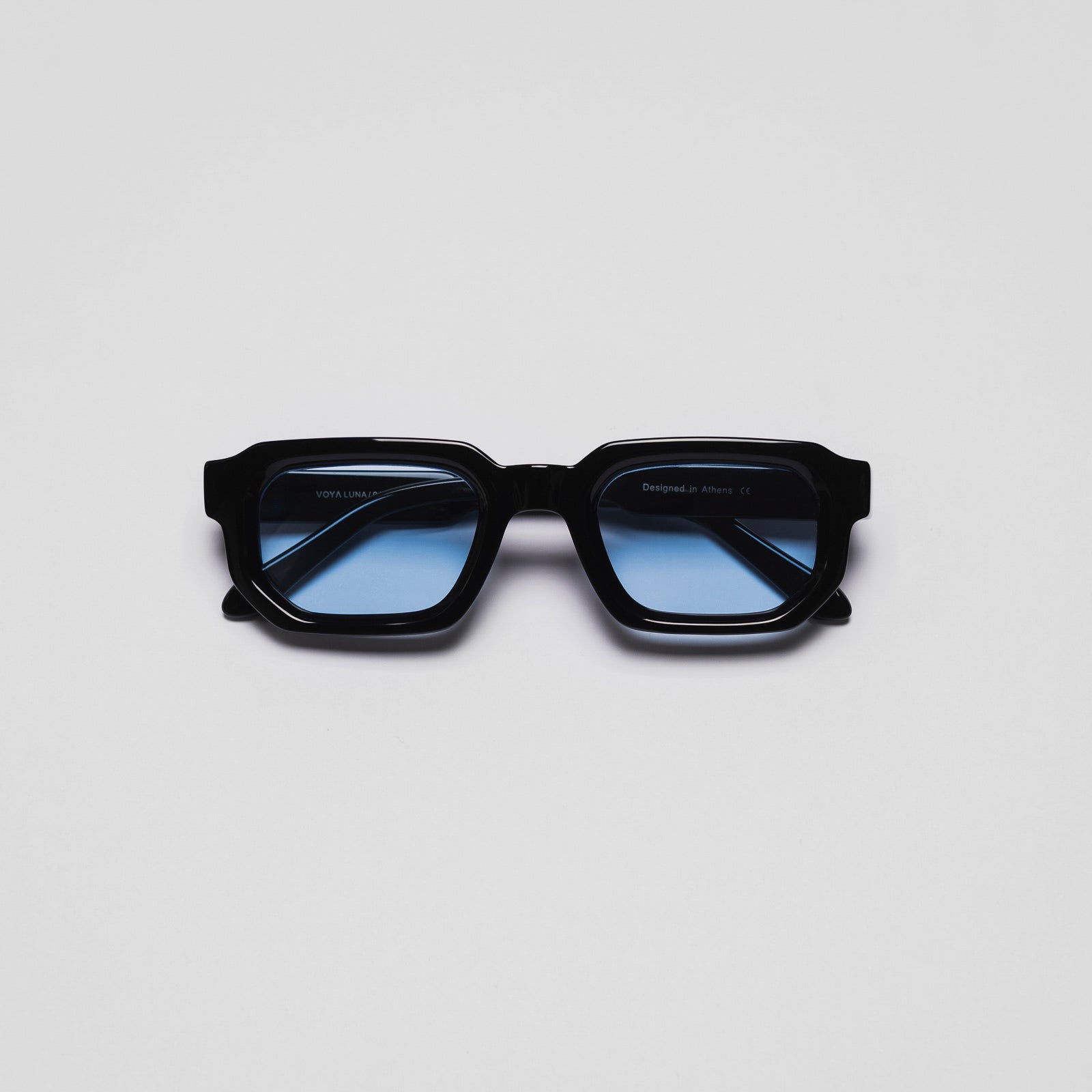 A pair of sunglasses with black frames and blue lenses on a white background.