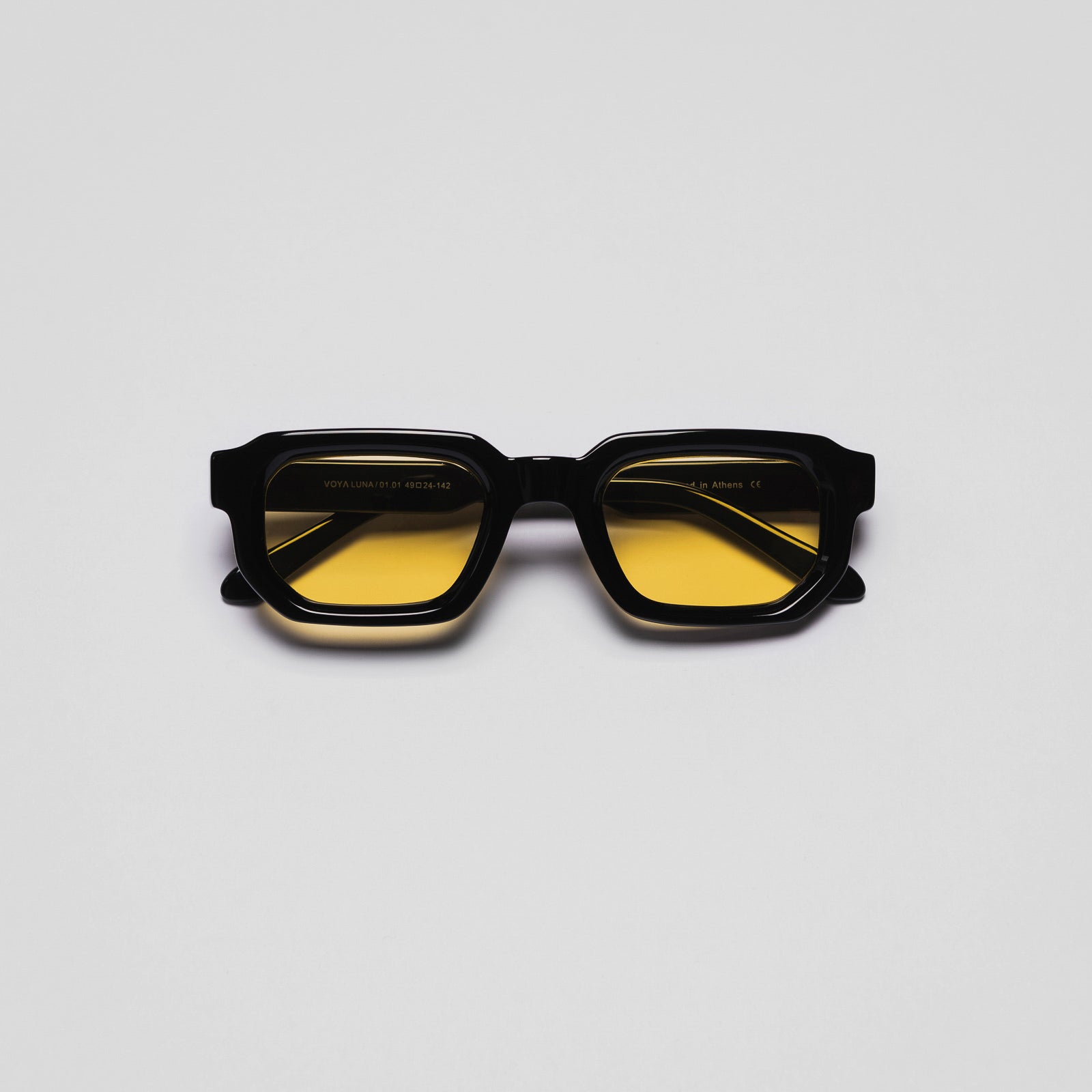 A pair of sunglasses with black frames and yellow tinted lenses.