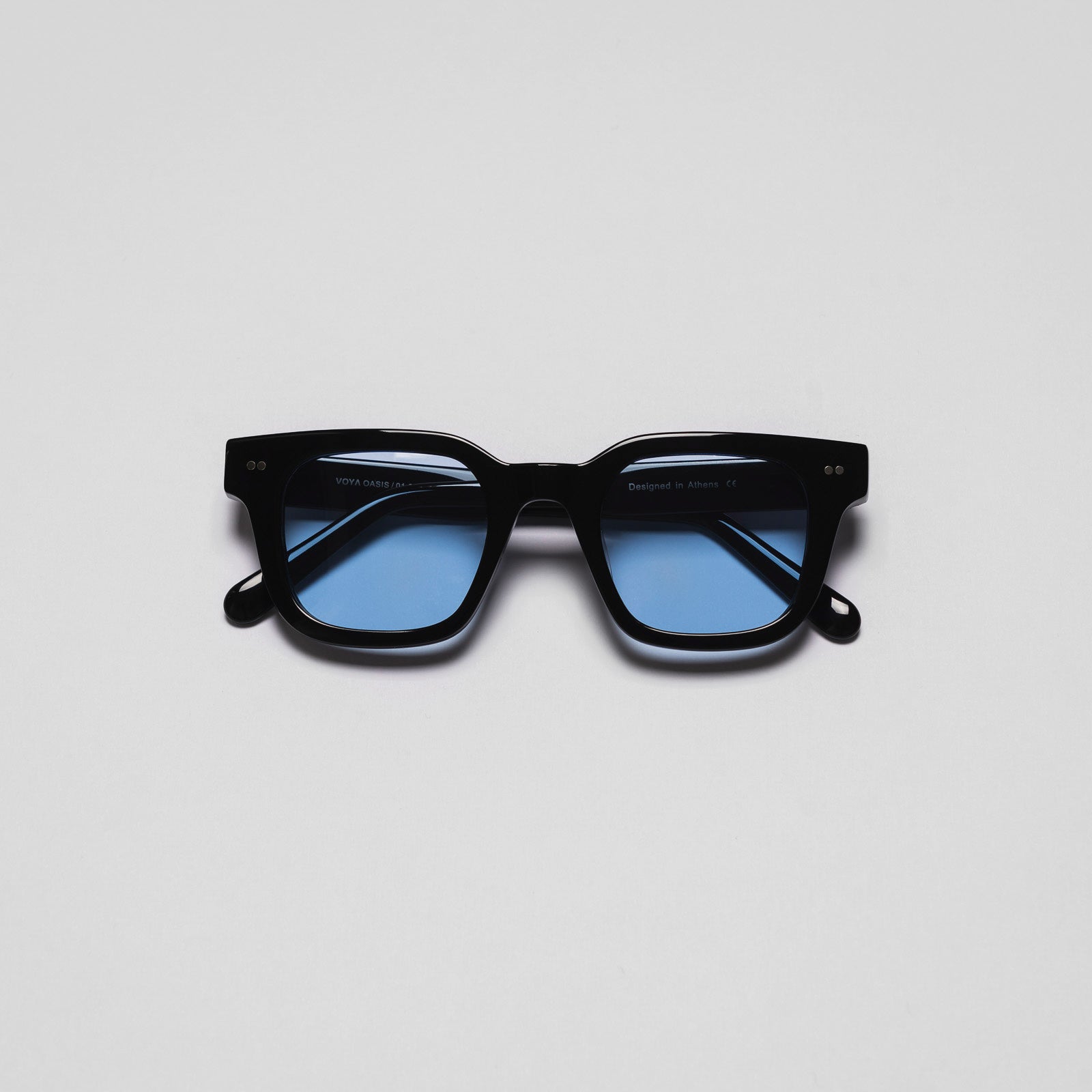 A pair of sunglasses with black frames and blue lenses on a white background.