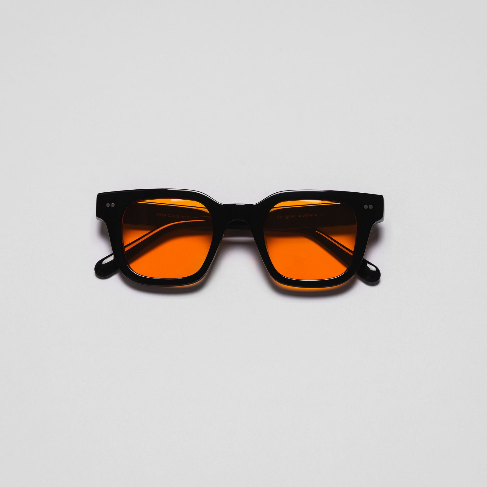 A pair of sunglasses with black frames and orange lenses on a white background.