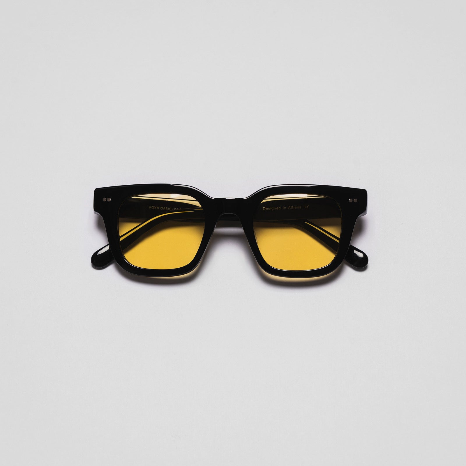 A pair of sunglasses with black frames and yellow tinted lenses.