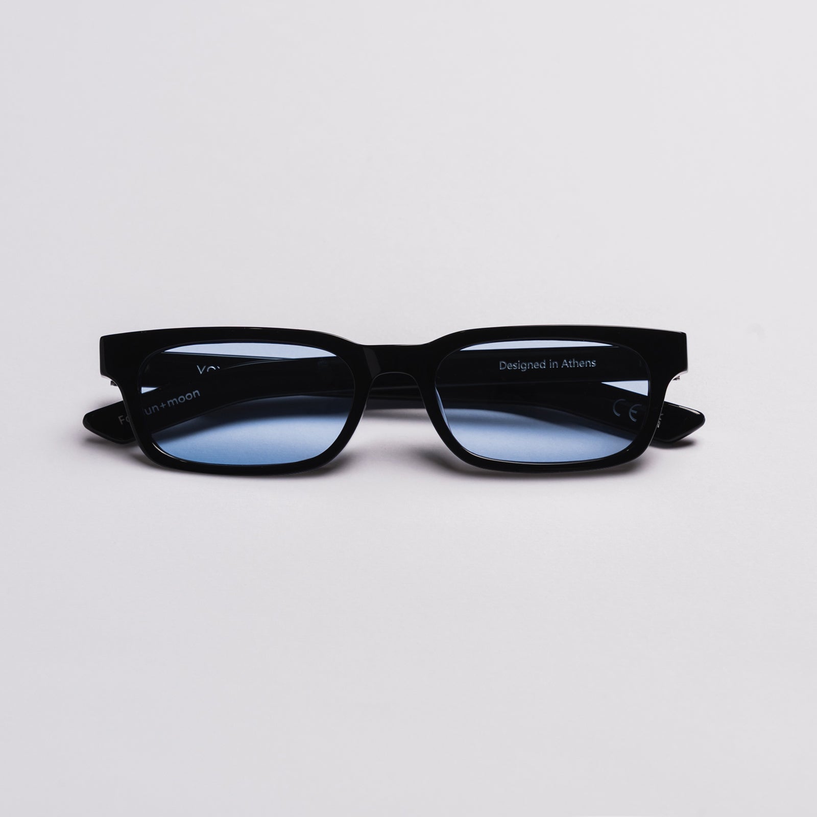 Black square VOYA eyeglasses with blue-tinted lenses, photographed on a clean light gray background.
