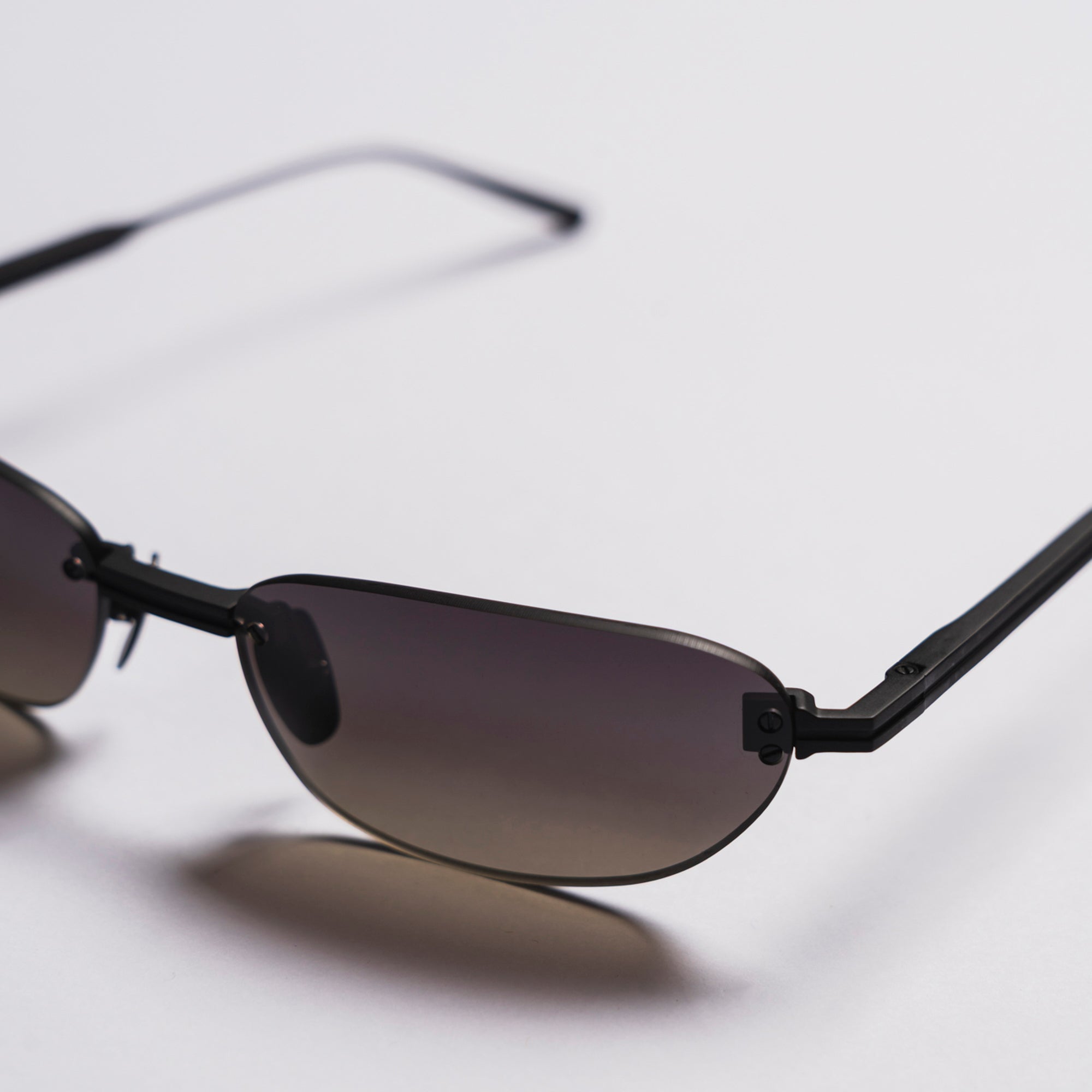 Black sunglasses with gradient lenses on a light gray background