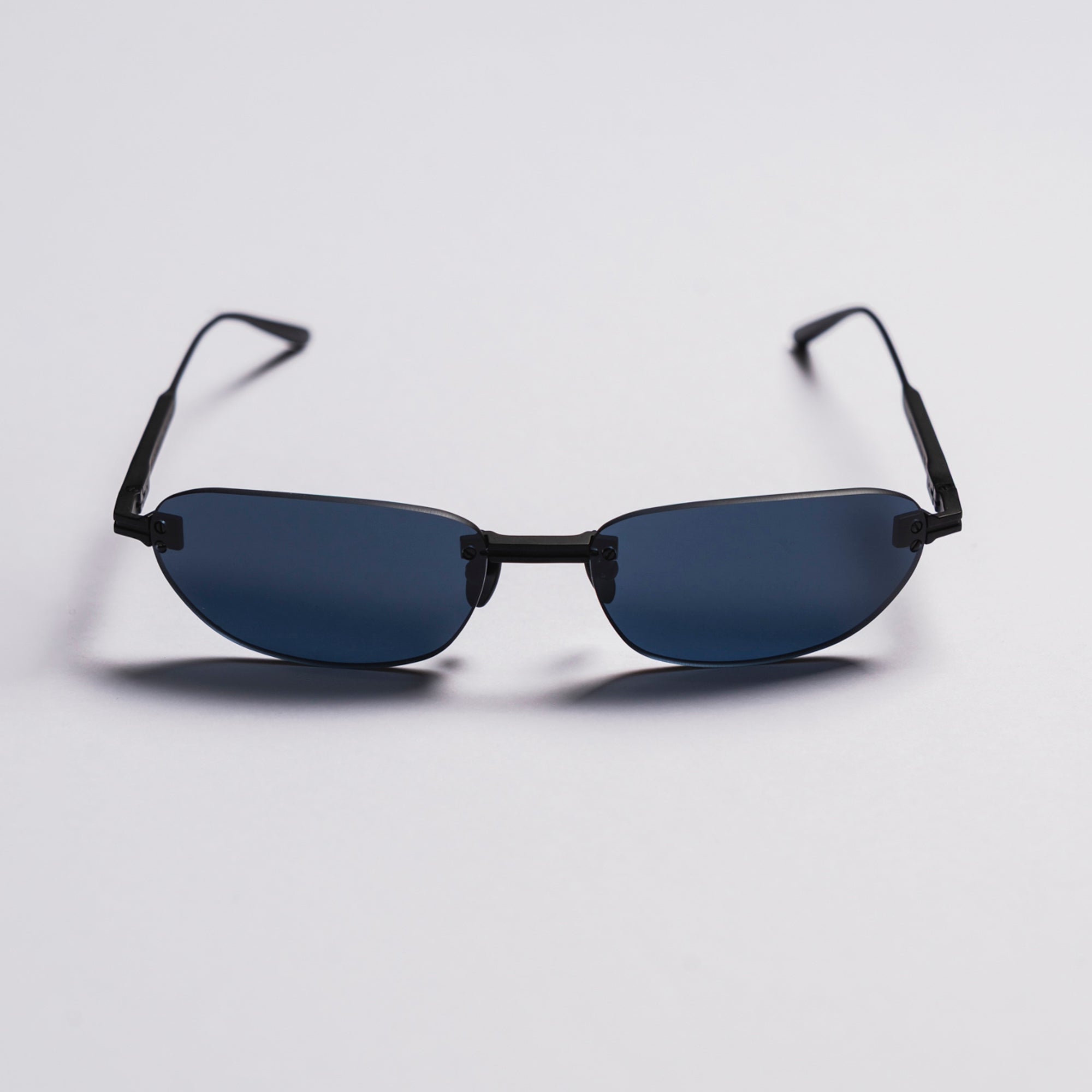 Sunglasses with black frames and blue lenses on a light gray background