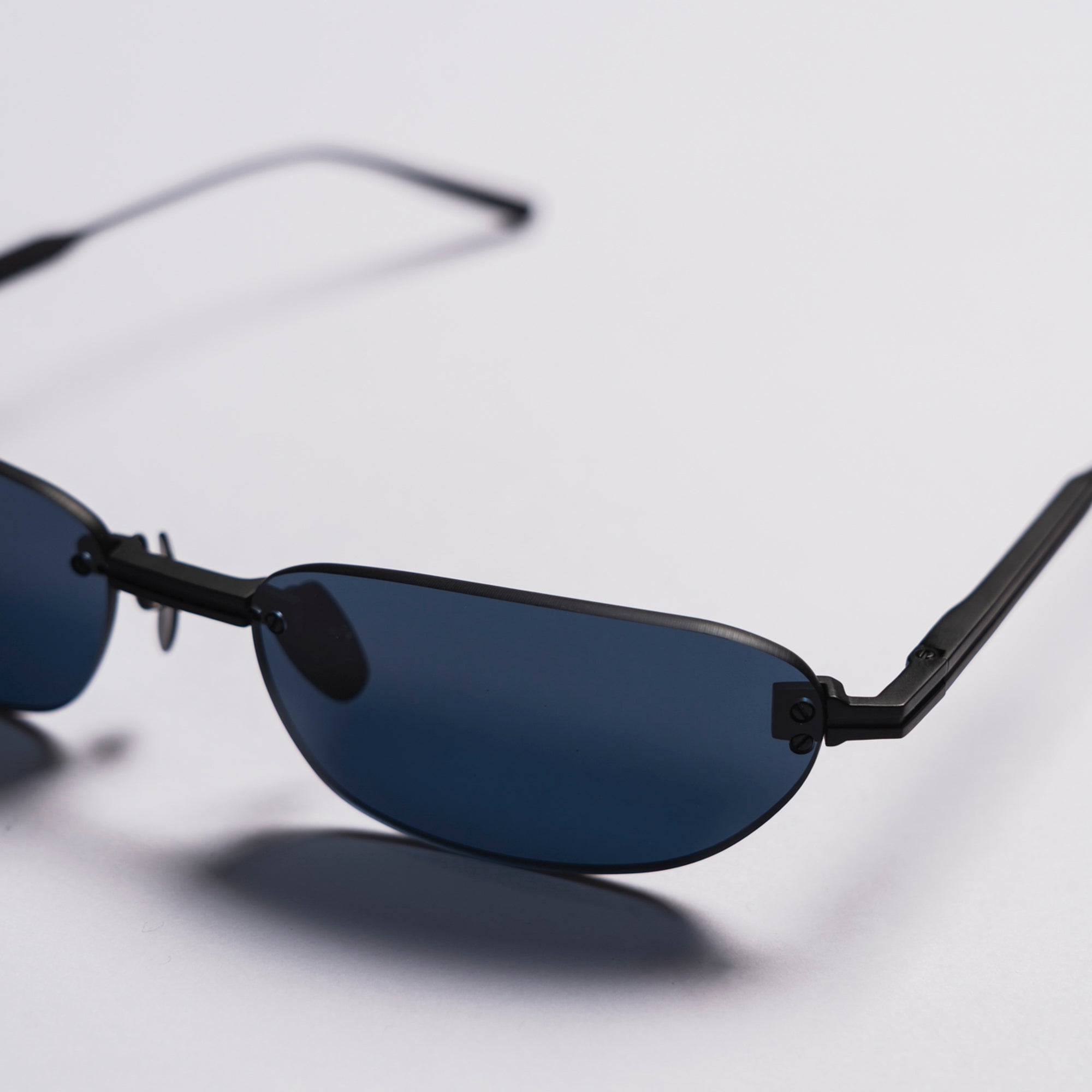 Sunglasses with black frames and dark lenses on a light gray background