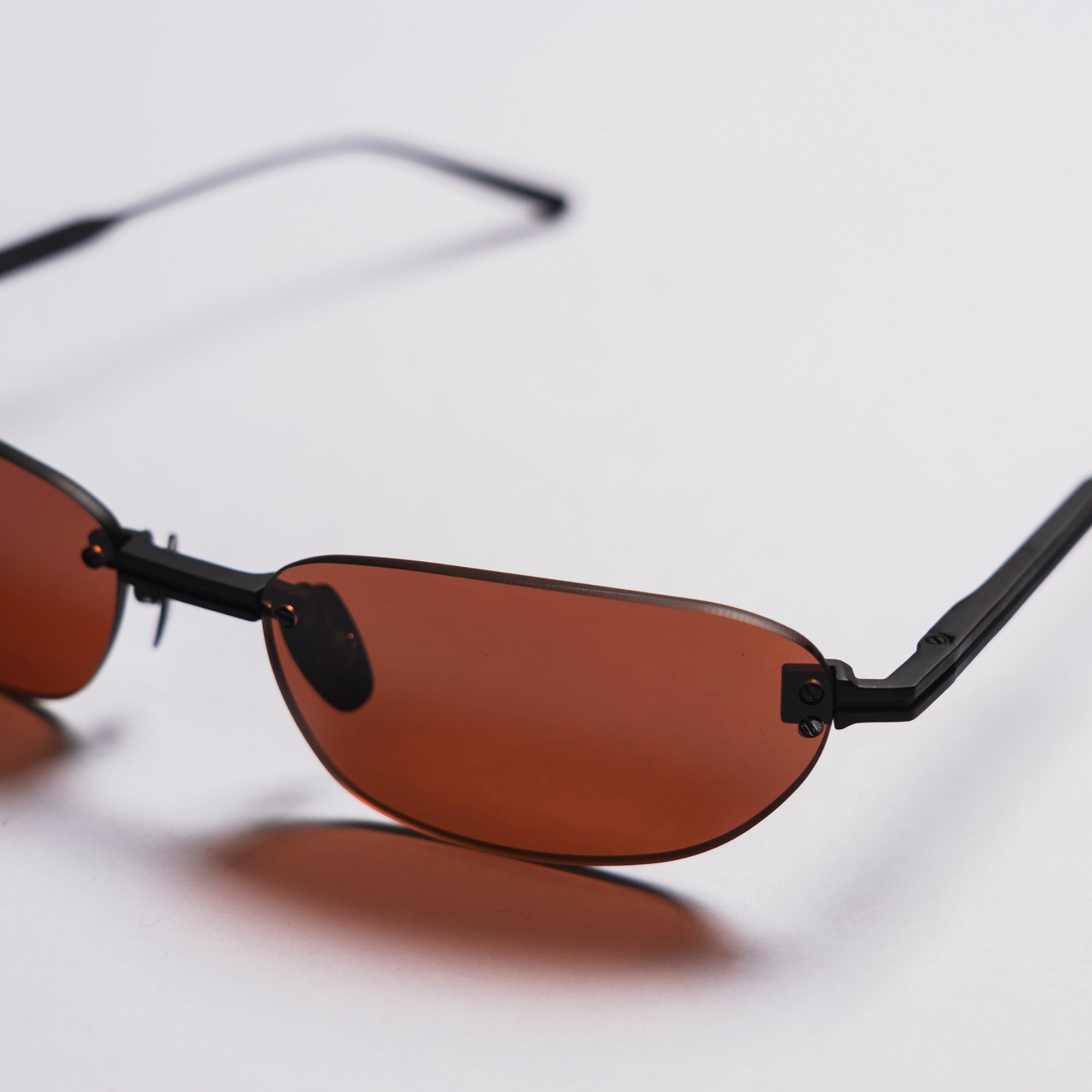 Sunglasses with brown lenses and black frames on a light gray background