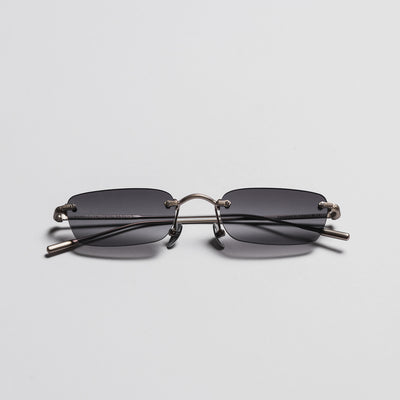 Sunglasses with a metallic frame and dark lenses on a light gray background