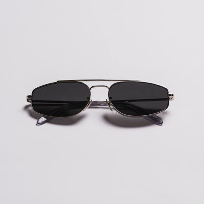 A pair of aviator-style sunglasses with dark lenses, a thin silver metal frame, and temple arms, shown on a light gray background.