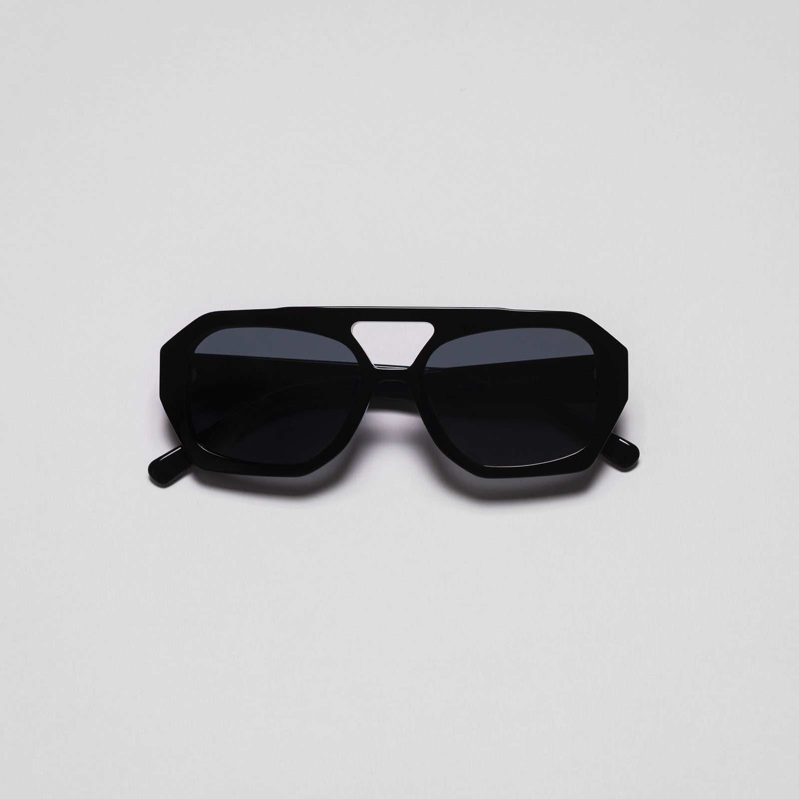 A pair of black sunglasses with a geometric design on a white background