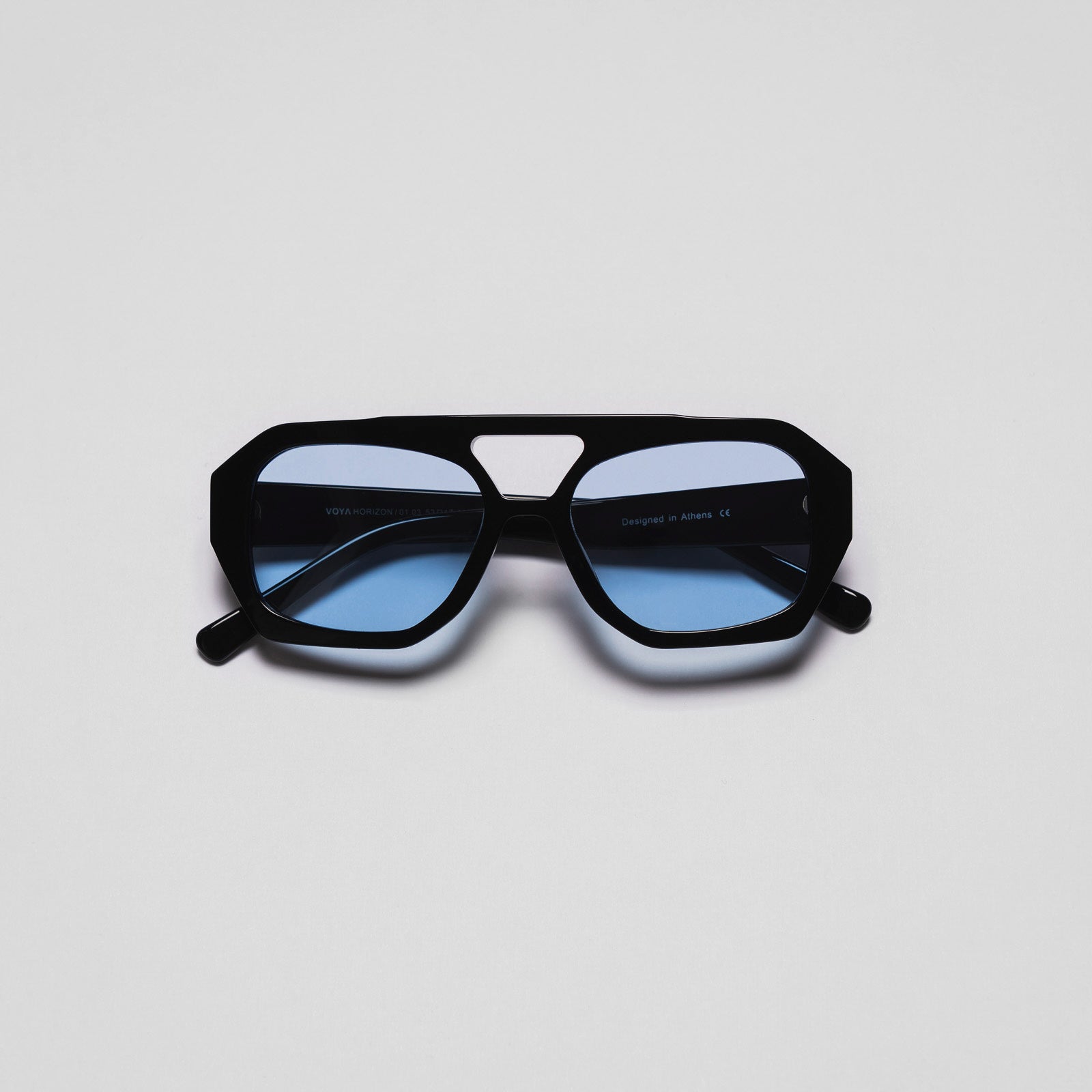 A pair of sunglasses with blue lenses and black frame, positioned against a white background.