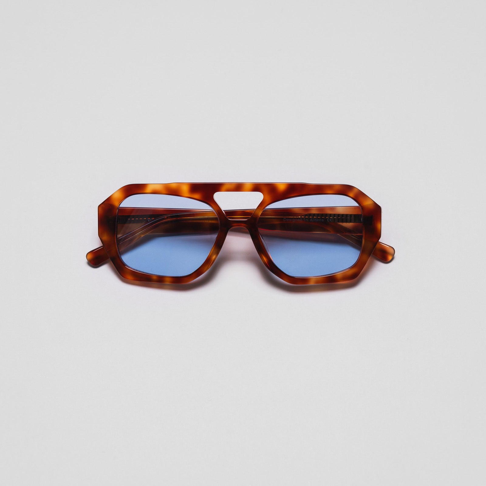 A pair of sunglasses with a hexagonal frame design and blue lenses.