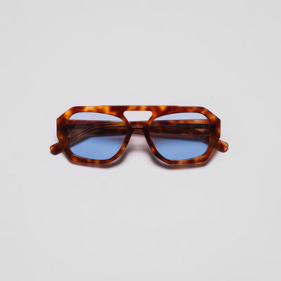 A pair of sunglasses with a hexagonal frame design and blue lenses.