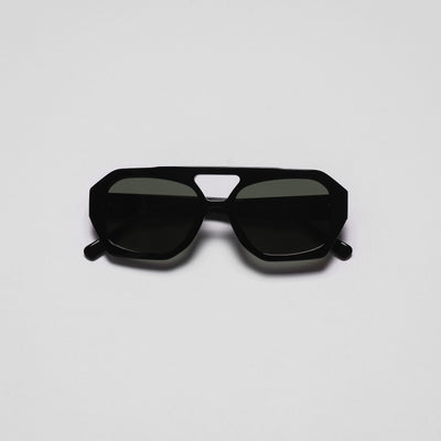 A pair of sunglasses with a black frame and dark lenses on a white background.