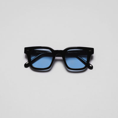A pair of sunglasses with black frames and blue lenses on a white background.