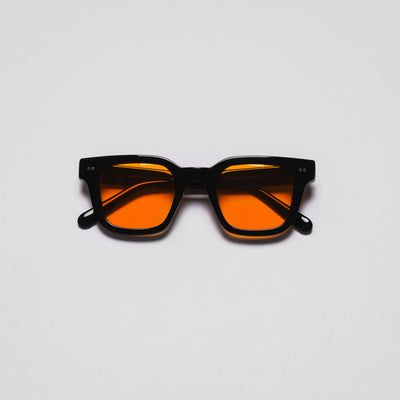 A pair of sunglasses with black frames and orange lenses on a white background.