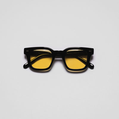 A pair of sunglasses with black frames and yellow tinted lenses.