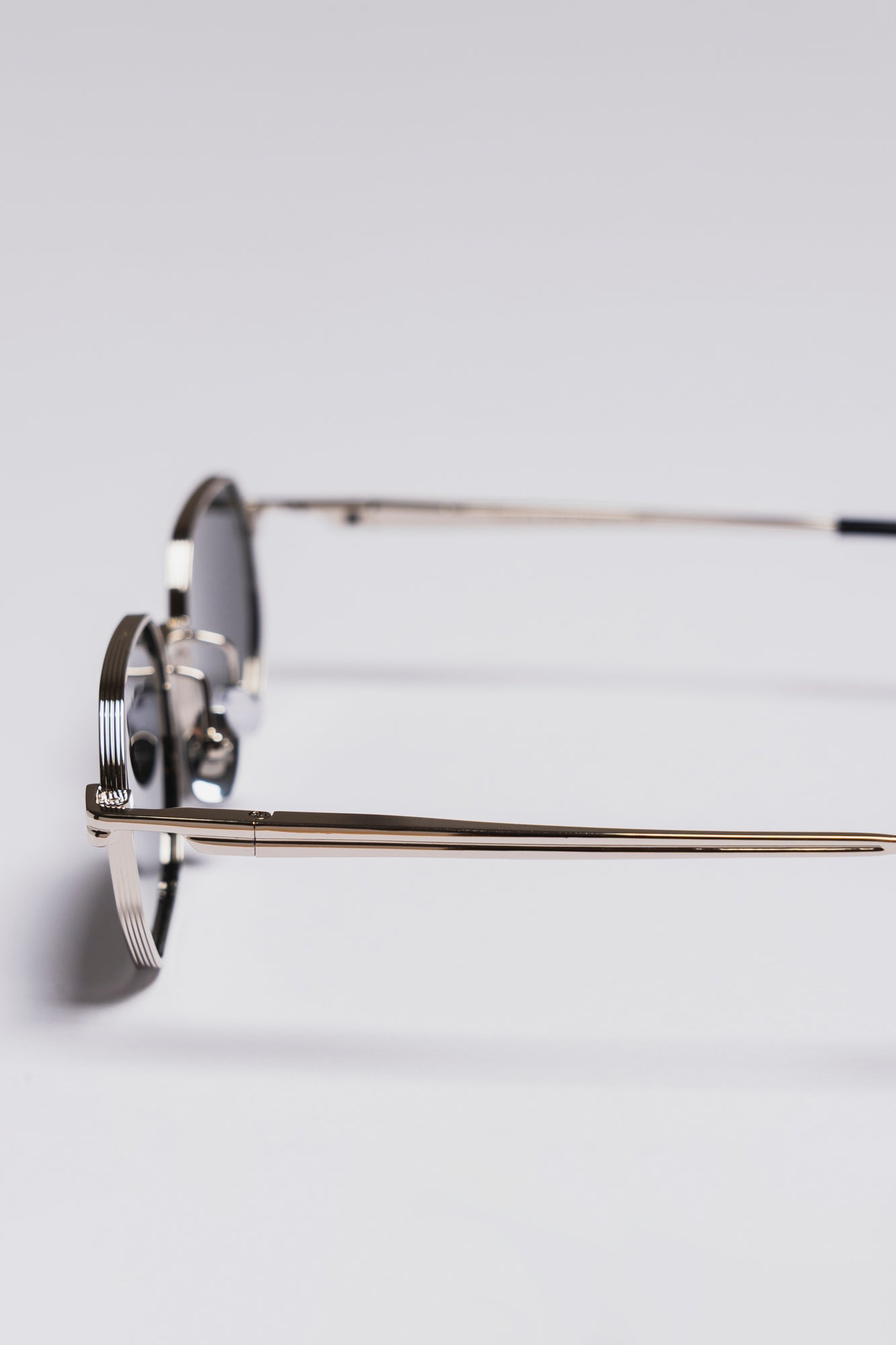 Eyeglasses with a reflective lens on a light gray background