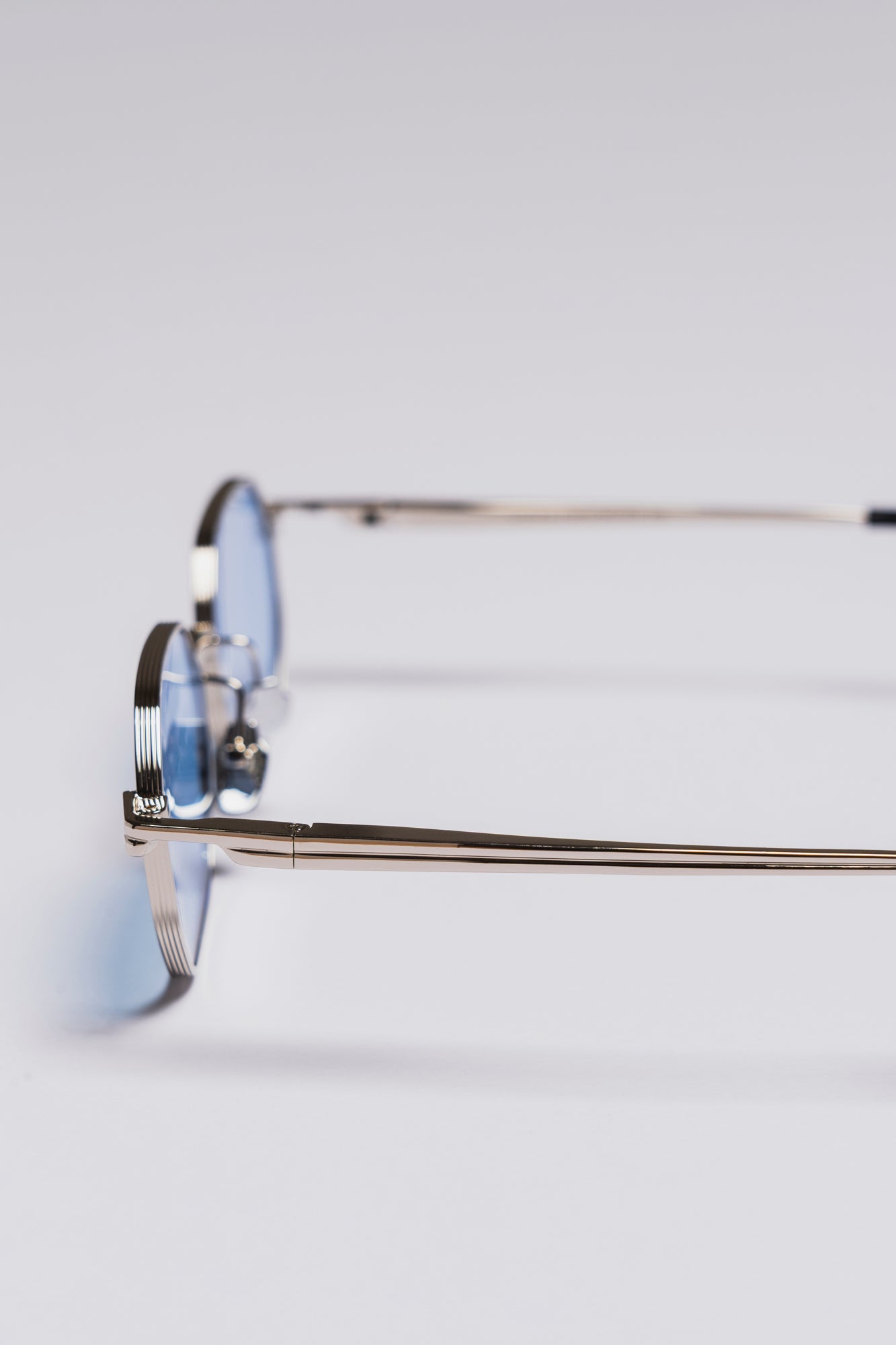 Eyeglasses with blue-tinted lenses on a light gray background