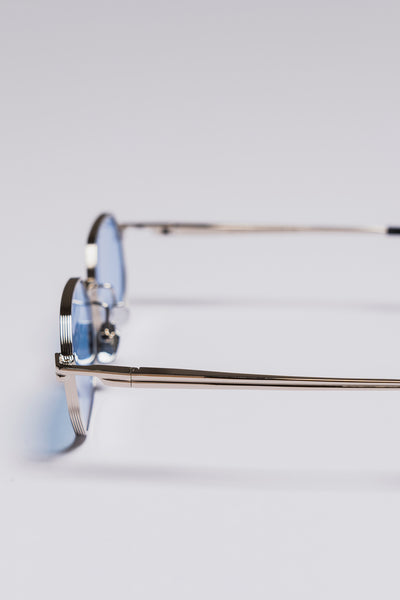 Eyeglasses with blue-tinted lenses on a light gray background